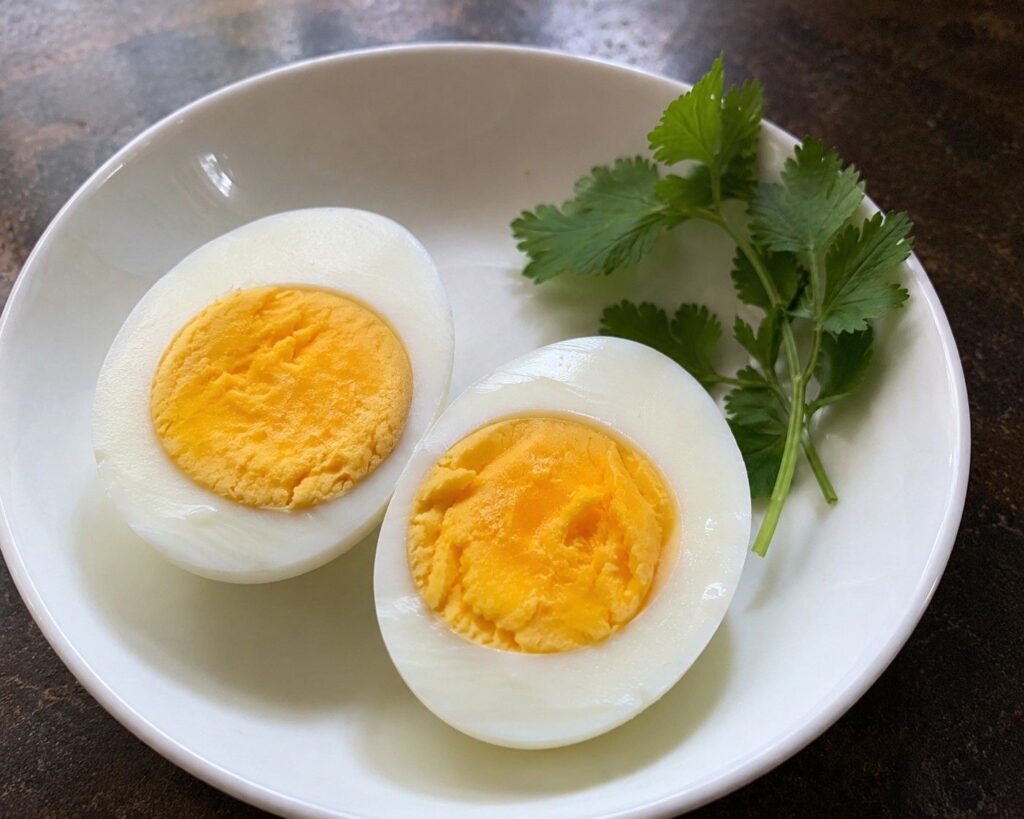 Two boiled eggs halved on a plate — a protein and biotin-rich breakfast food for hair growth